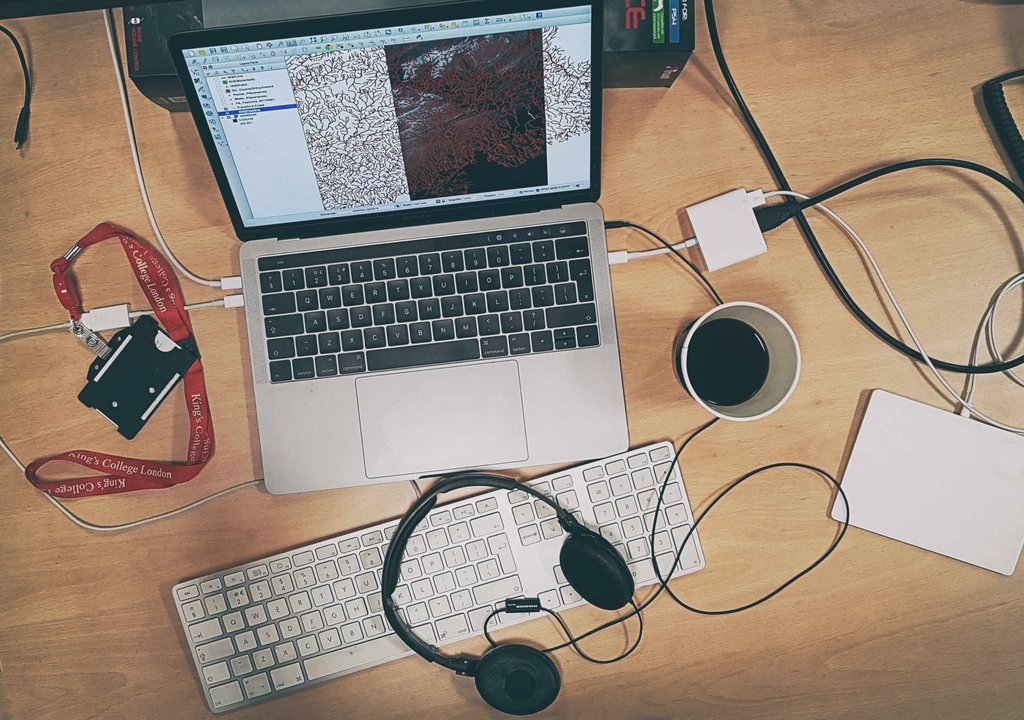 A desk arrangement showcasing a laptop, headphones, and a cup of coffee.